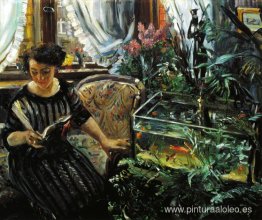 Mujer junto a una pecera de peces de colores Mujer junto a una pecera de peces de colores